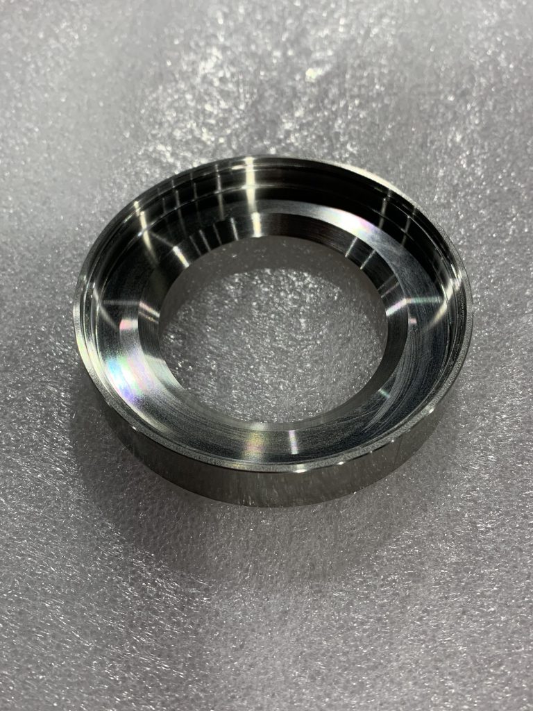 旋盤加工で製作された加工品の一例です。金属の中心に大きな穴が空いている円筒形となります。